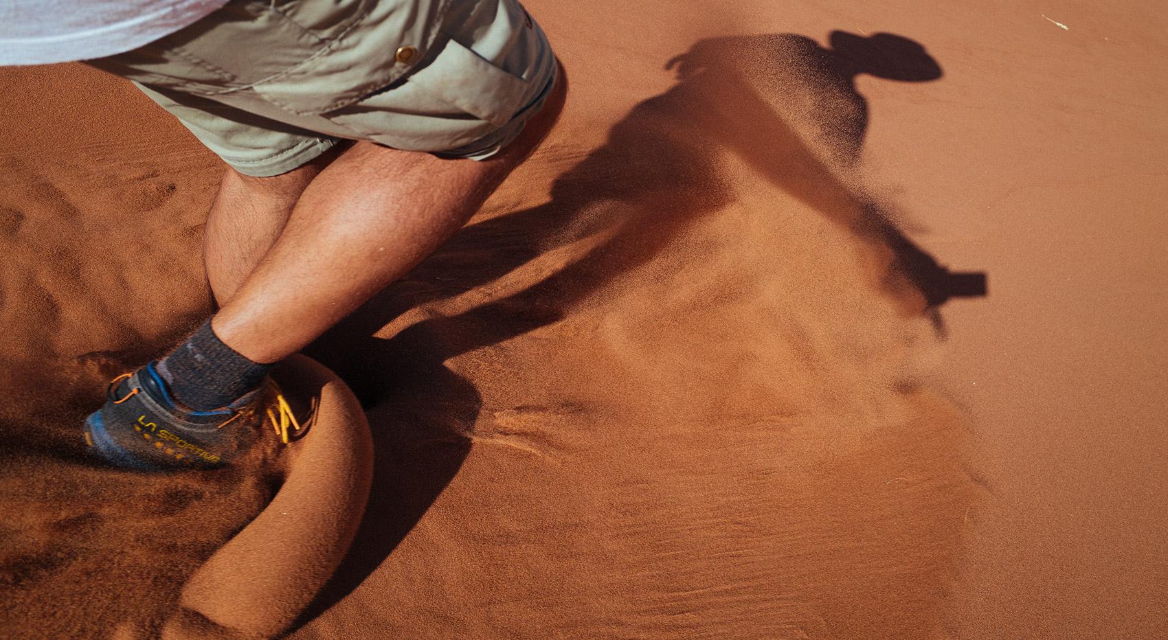 Man running down a sand dune in Sossusvlei Man running down a sand dune in Sossusvlei