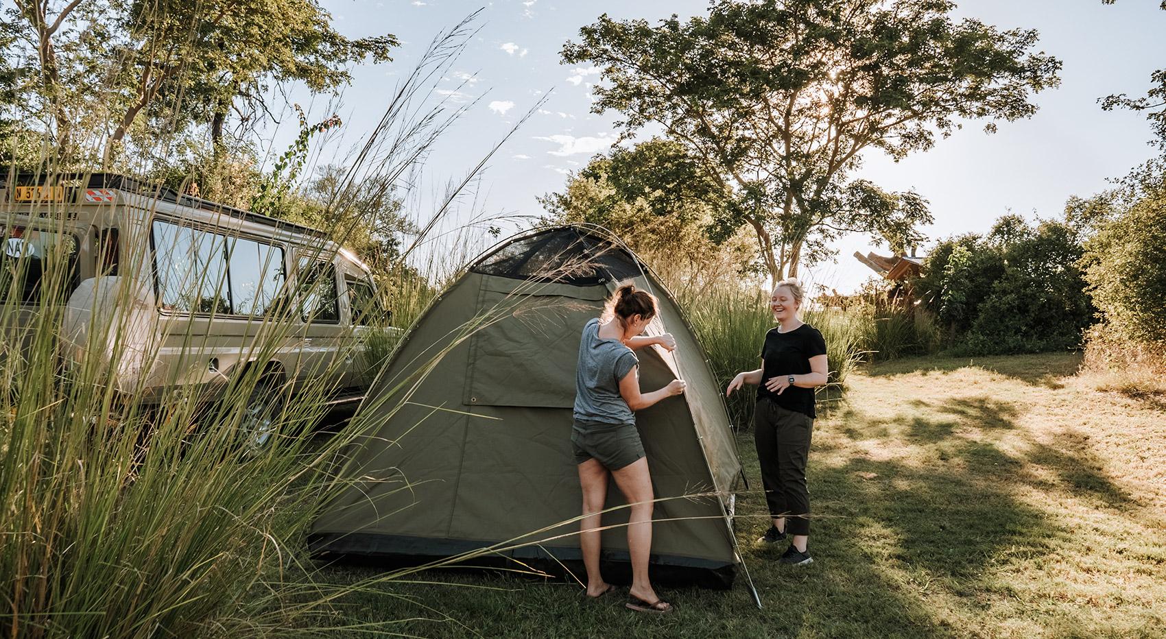 Menschen, die Zelte auf einem Campingplatz in Namibia aufbauen