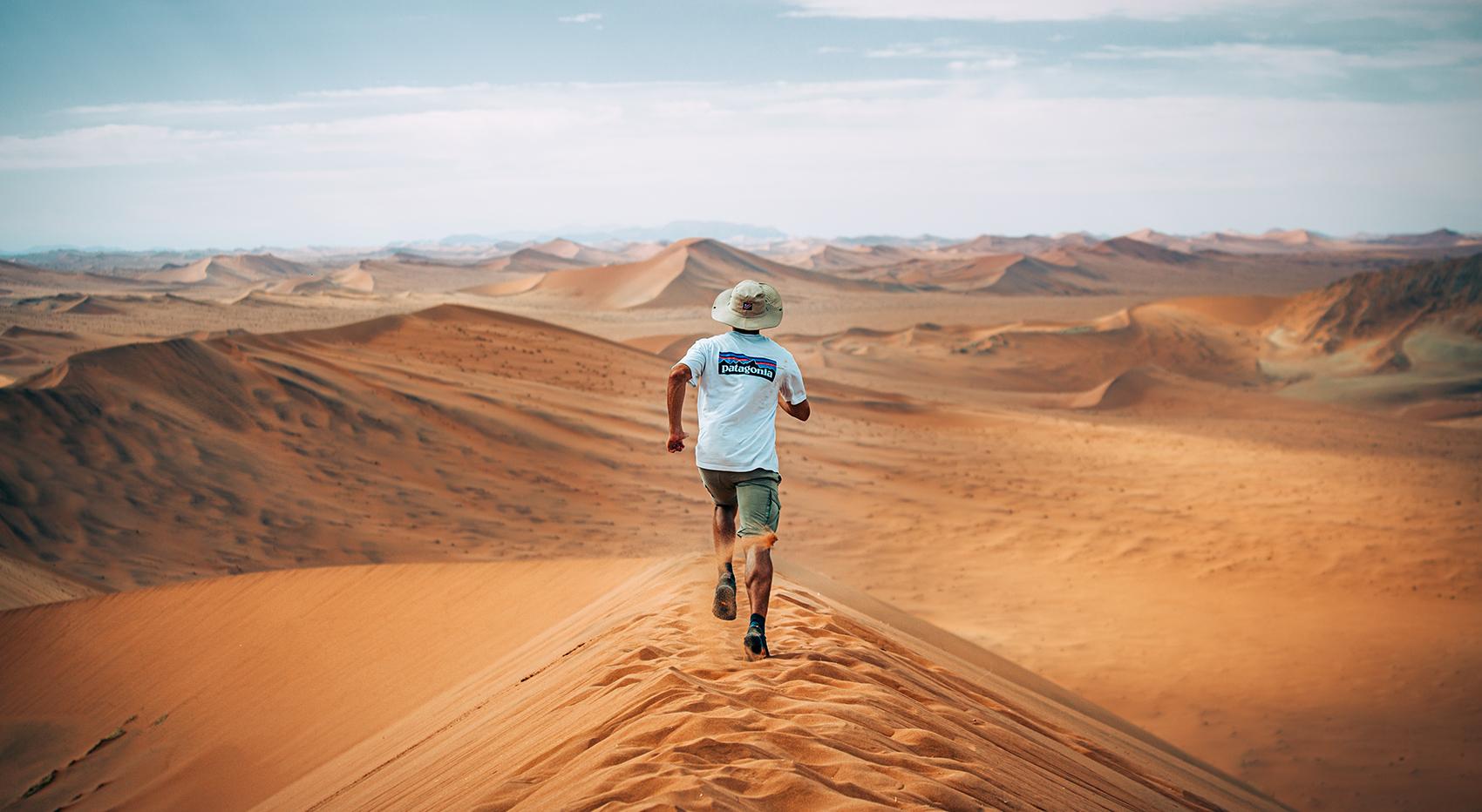 A man runs on the dunes of the Namib Desert. A man runs on the dunes of the Namib Desert.