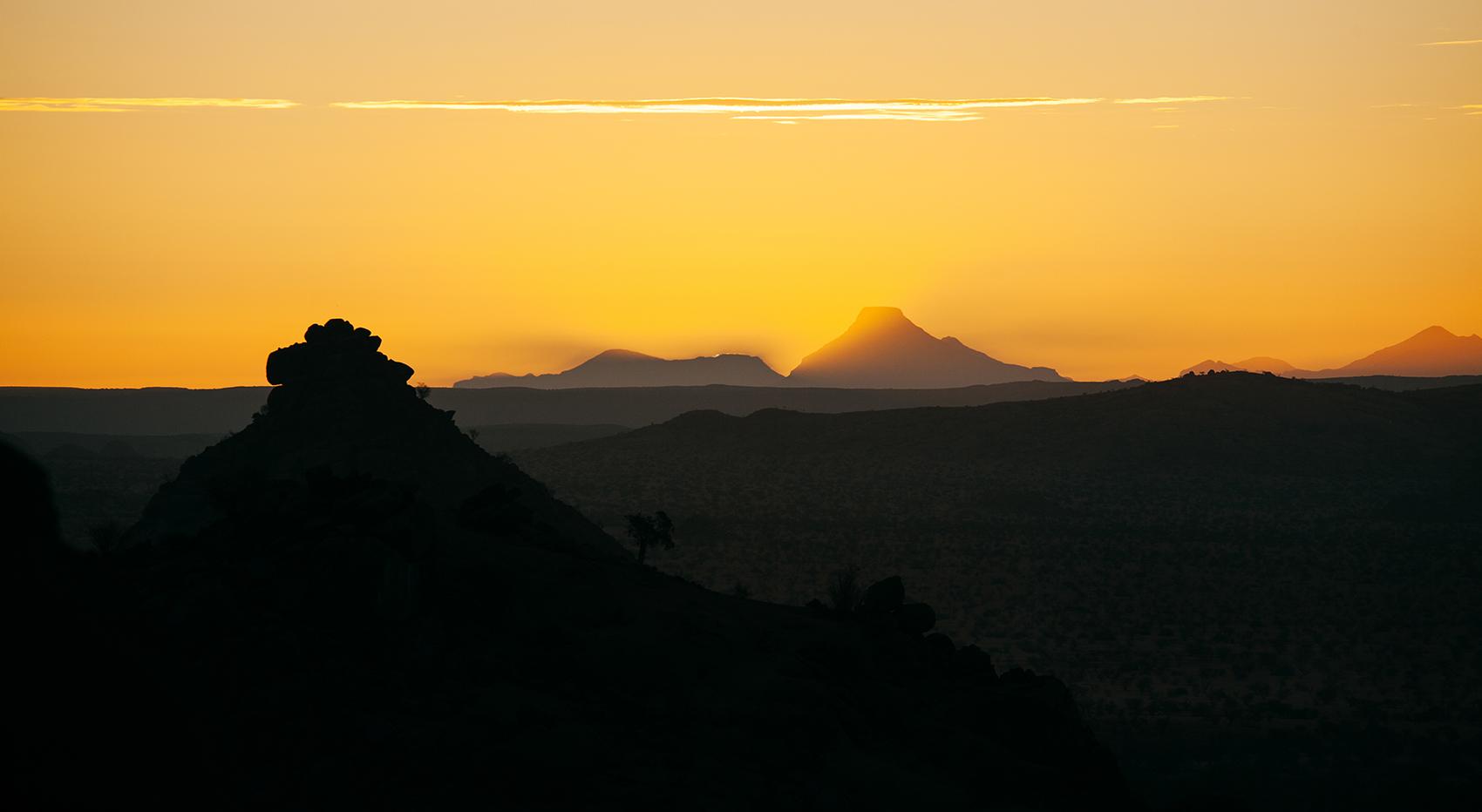The sunset at Malansrus Tentet Camp. Mountains illuminated by the orange colour of the sun. 