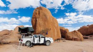 A self-drive vehicle with roof top tent all set up at Spitzkoppe campsite.