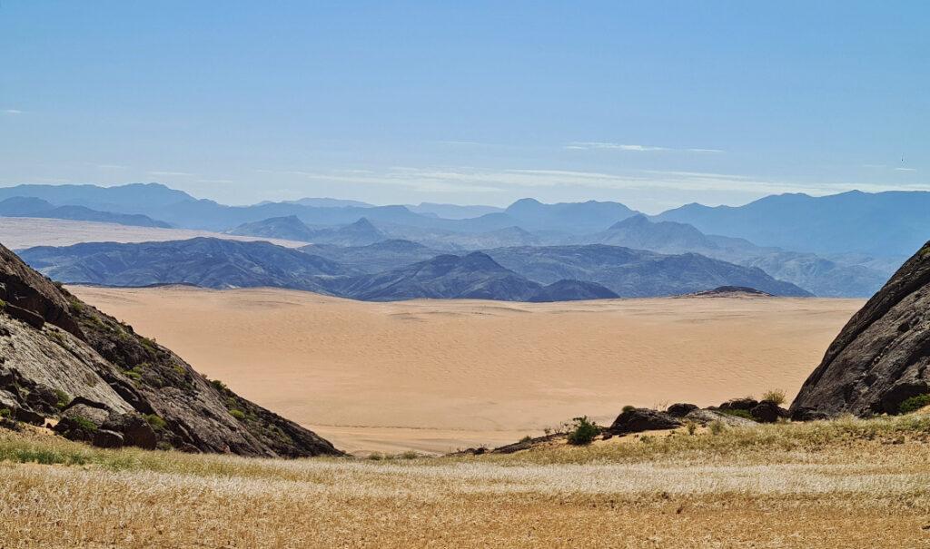 View of the Hartmann's Valley in northern Namibia with a mountain range on the horizon and blue sky above.