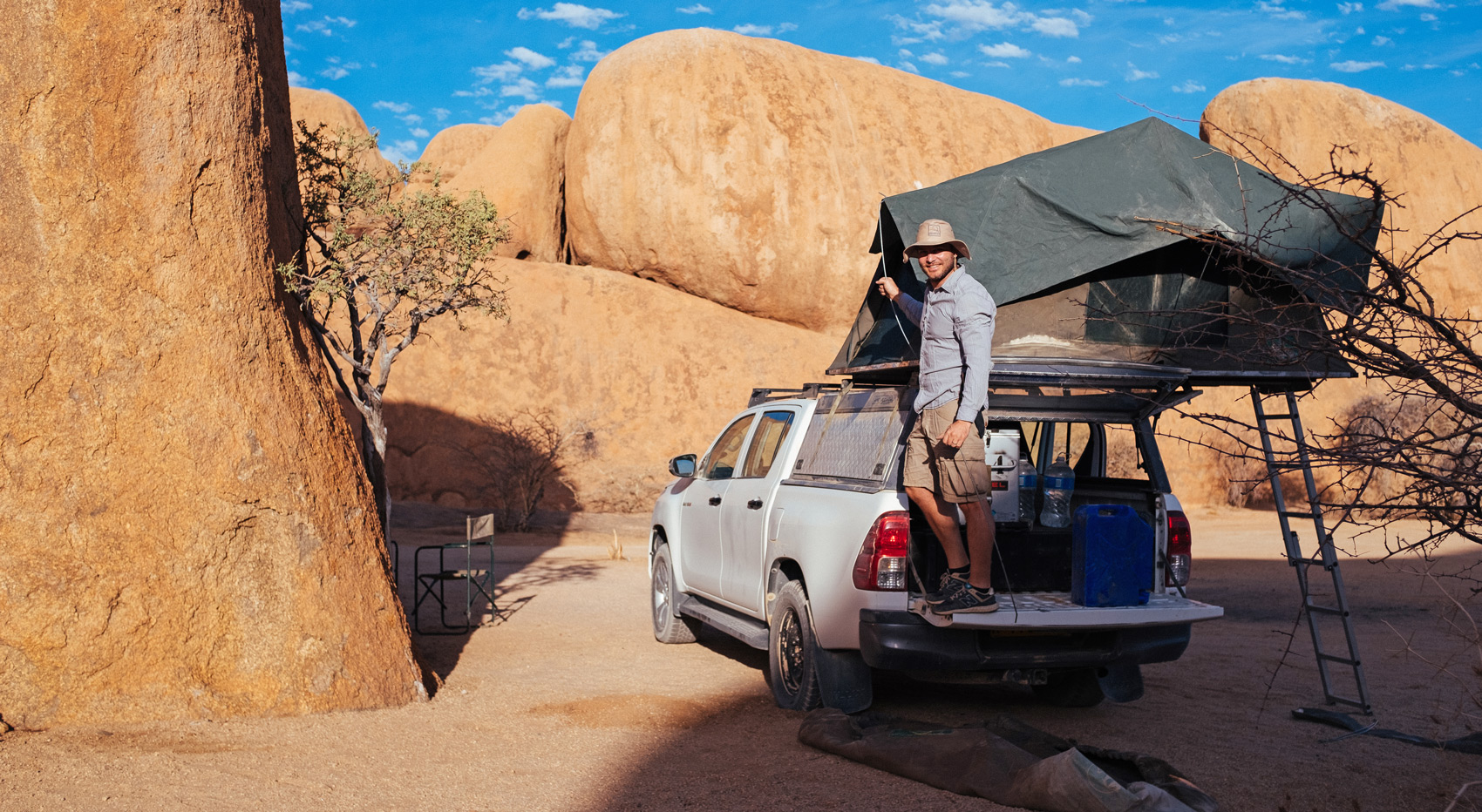 A tourist setting up camp with his roof top tent in Namibia.