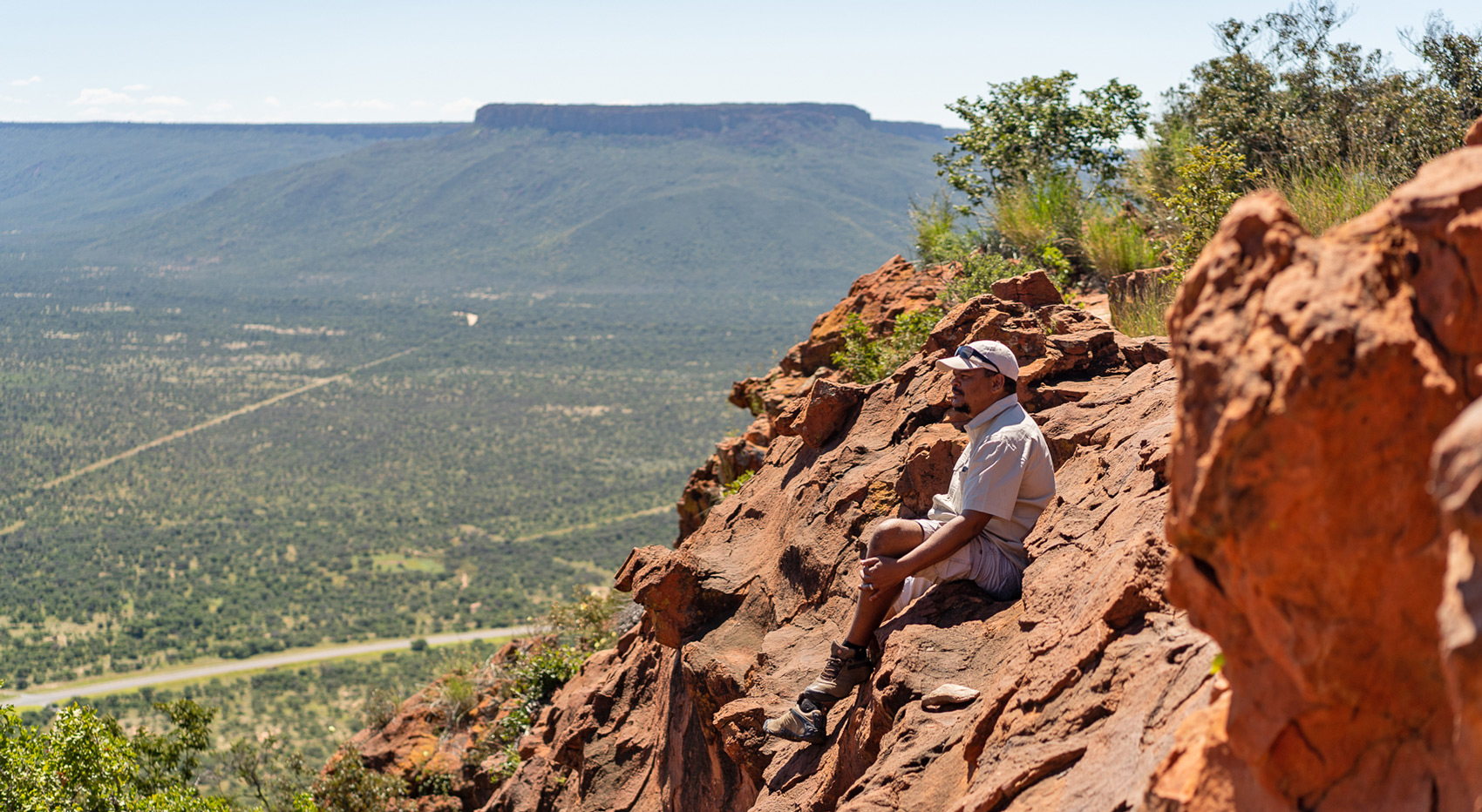 A hiker restng on rocks at the Waterberg Plateau.