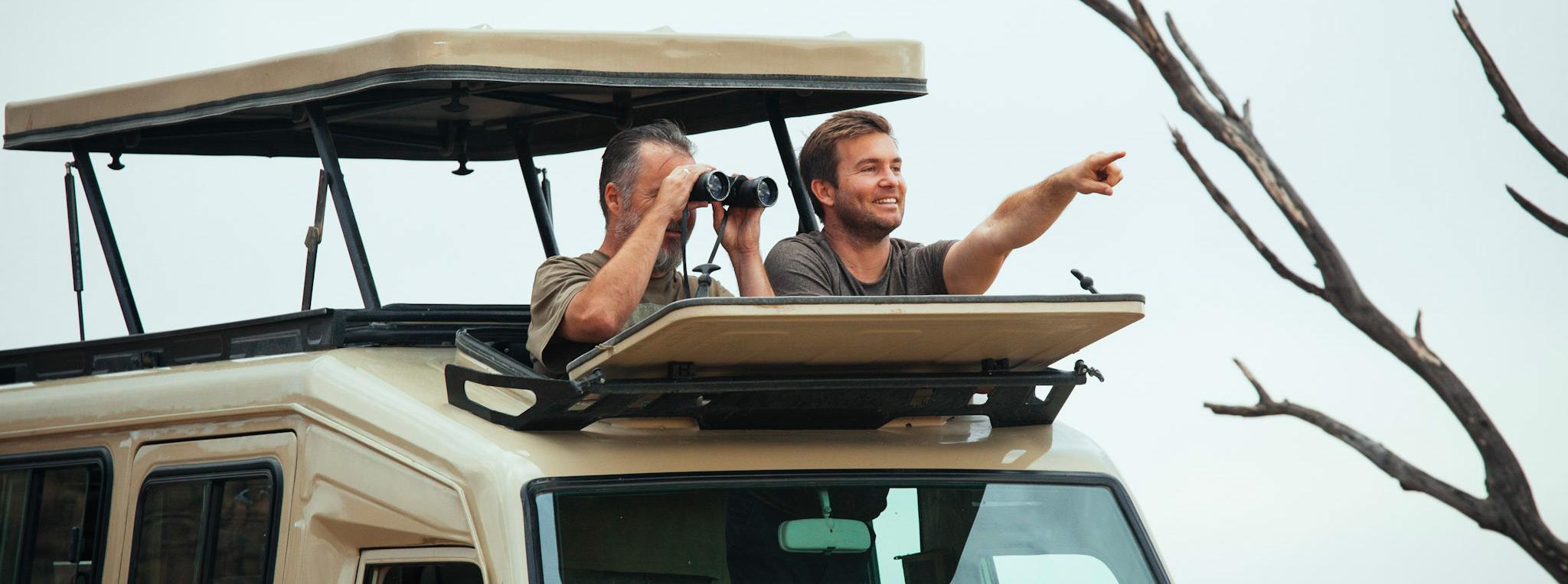 Gäste schauen Wildtiere in Namibia durch das Aufklappdach an.