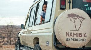 A young child looking out of the window of a game-drive vehicle.