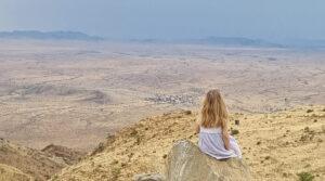 A girl sitting on a rock in the Namib Desert.