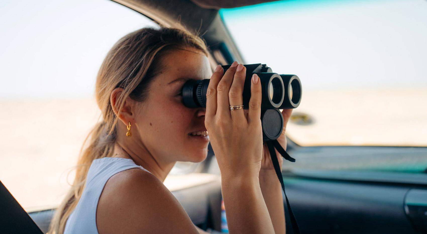 A self drive tourist looking through binoculars. A self drive tourist looking through binoculars.